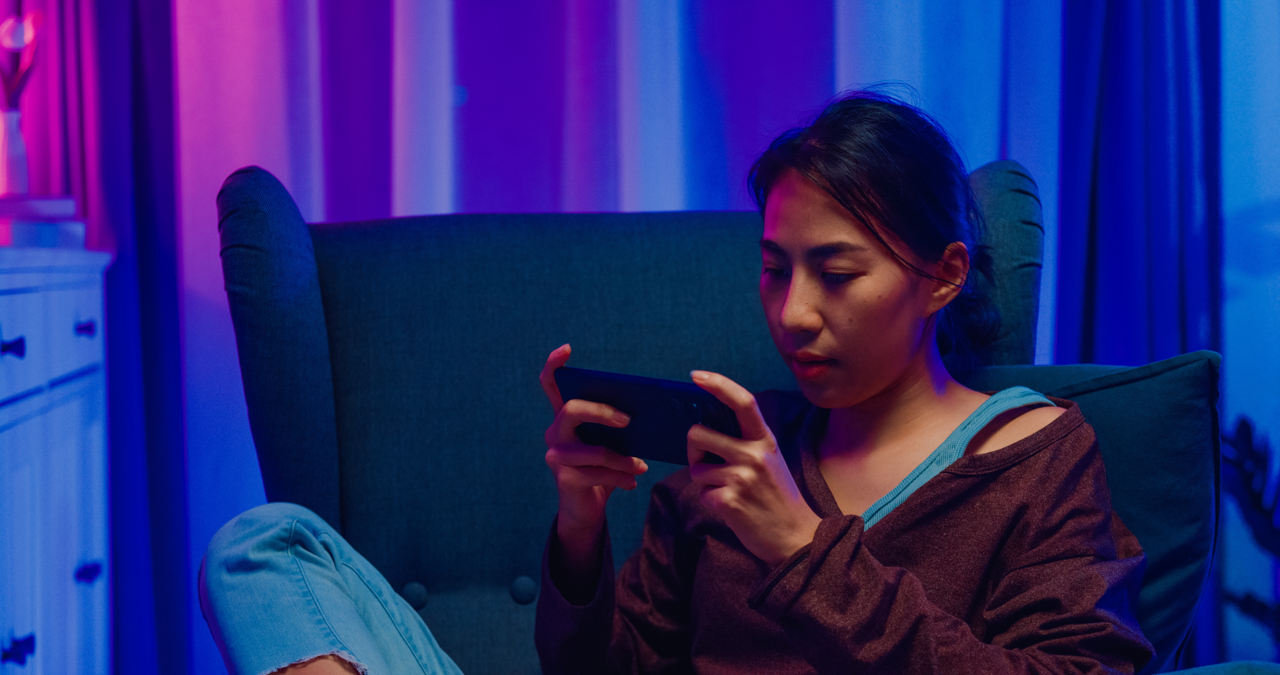 person on couch using smartphone