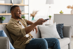 man pointing remote at tv