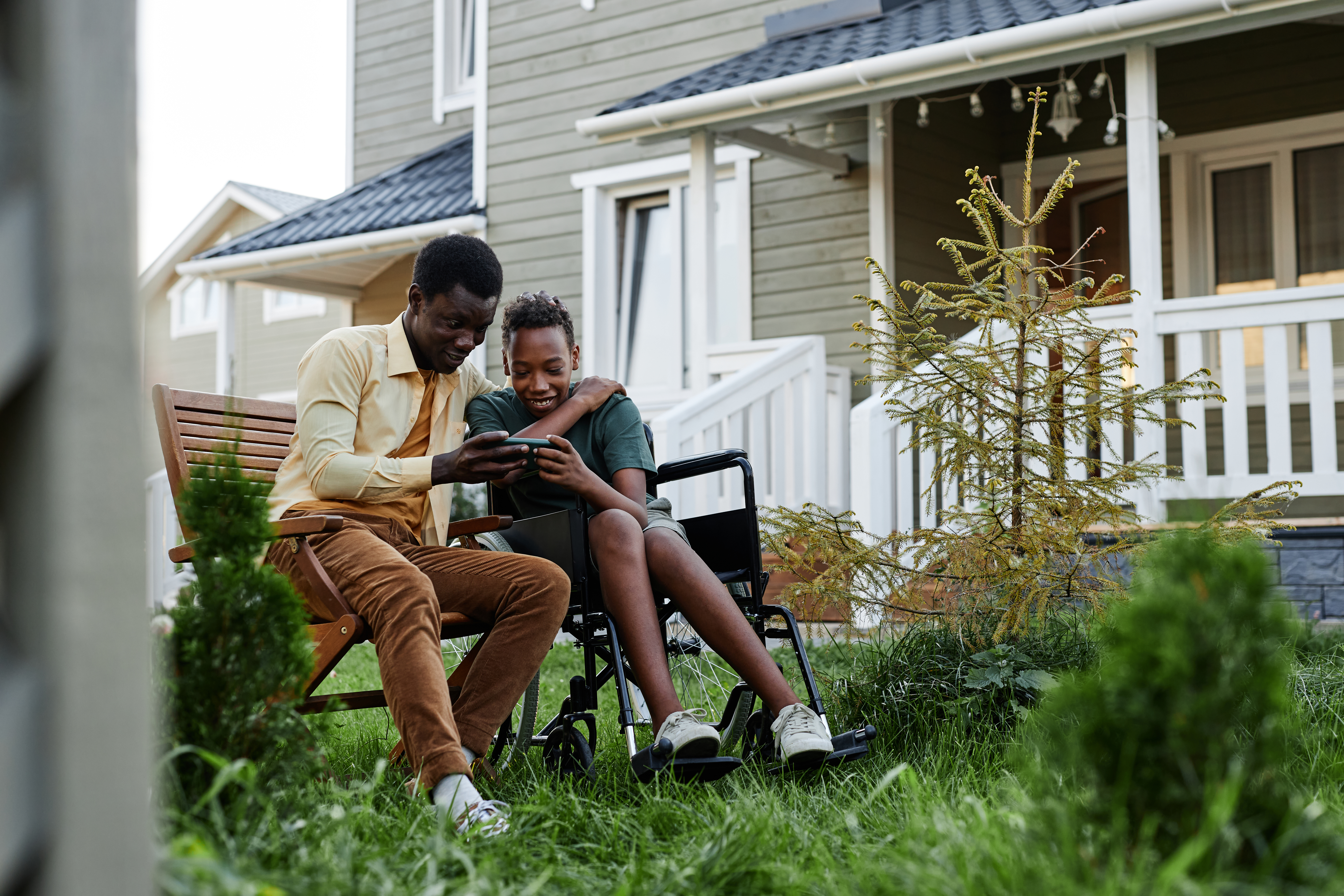two kids engaging with phone outside 