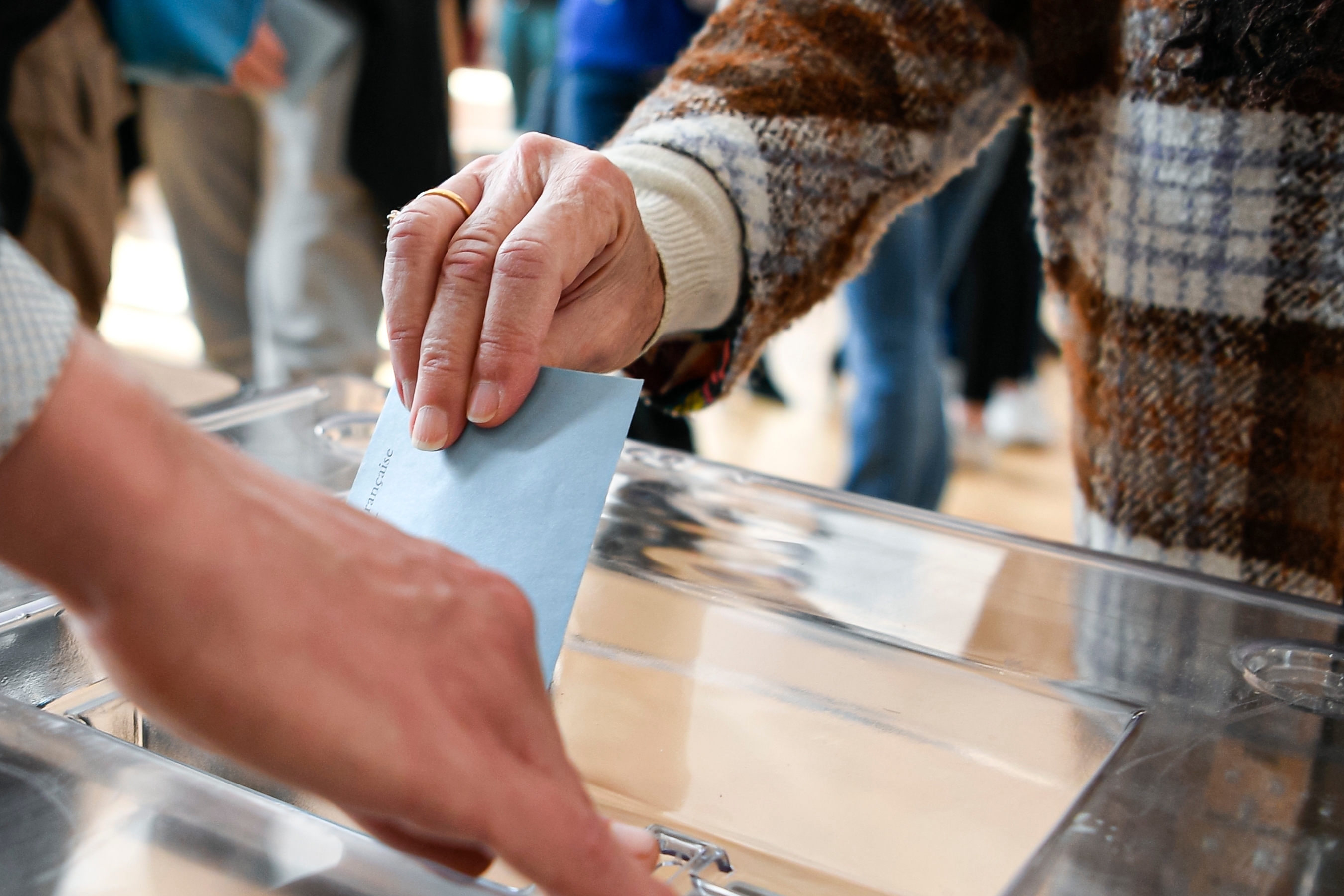 person putting ballot into ballot box