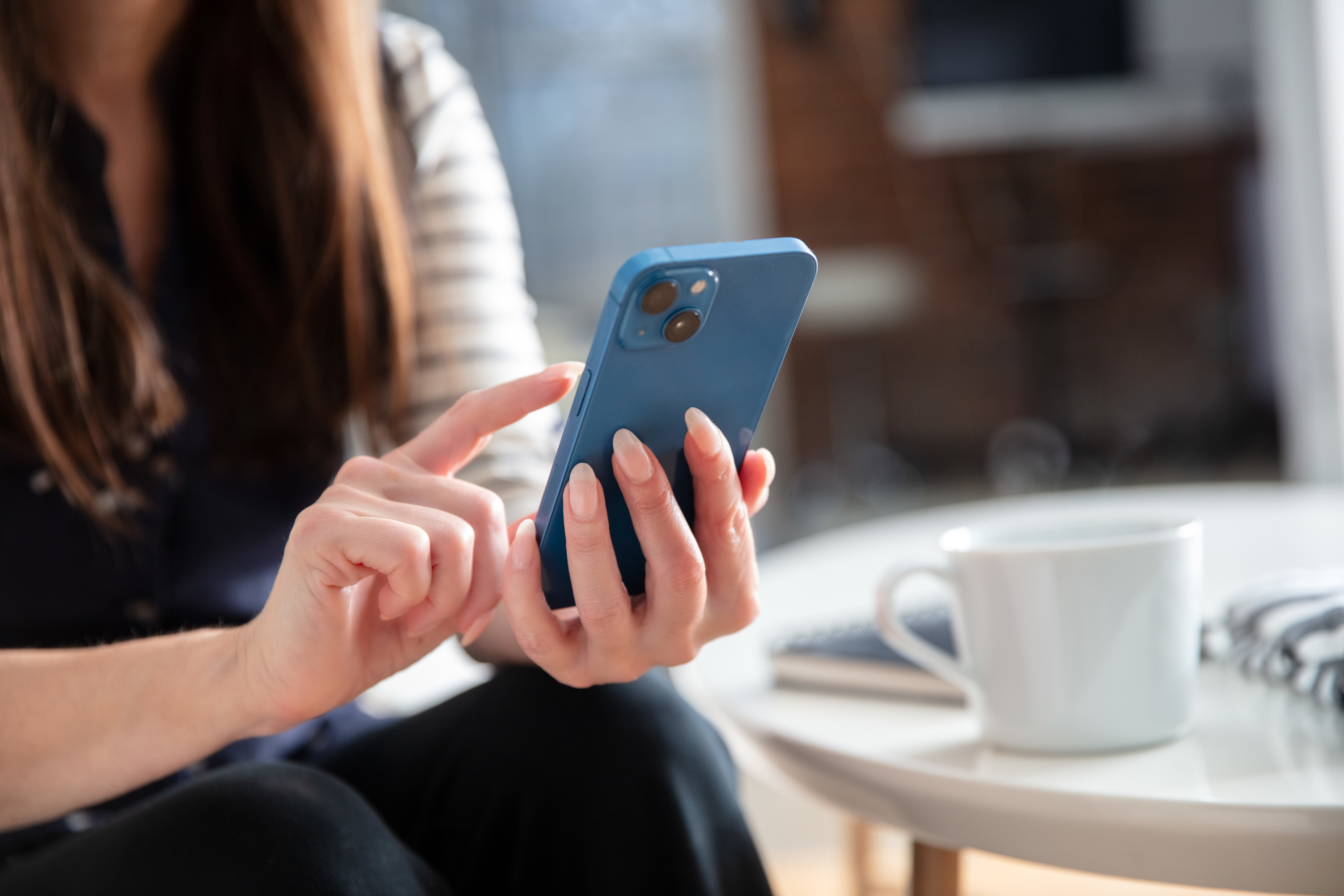 Woman's hand scrolling through phone