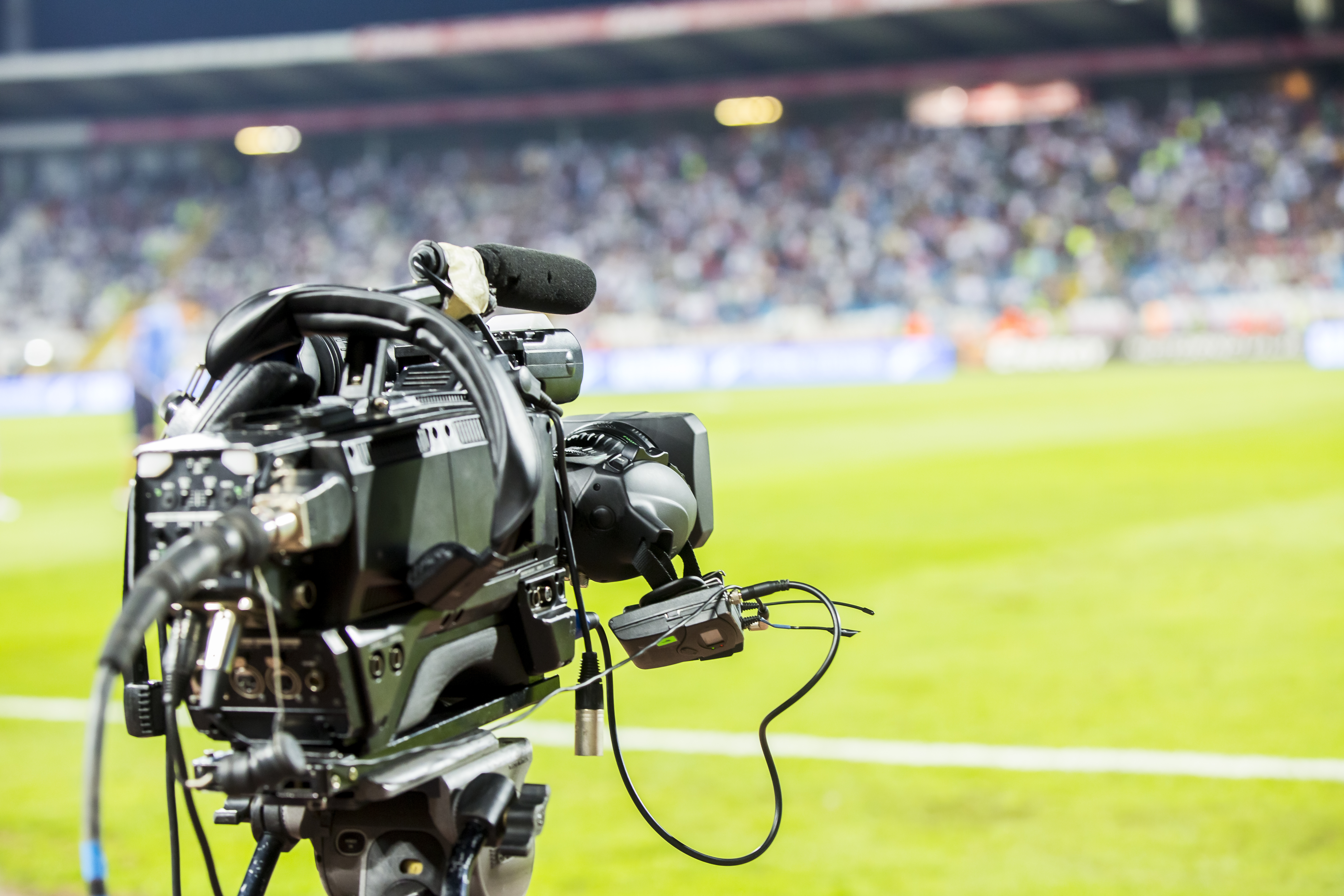 Broadcast camera positioned beside a sports field during a live event