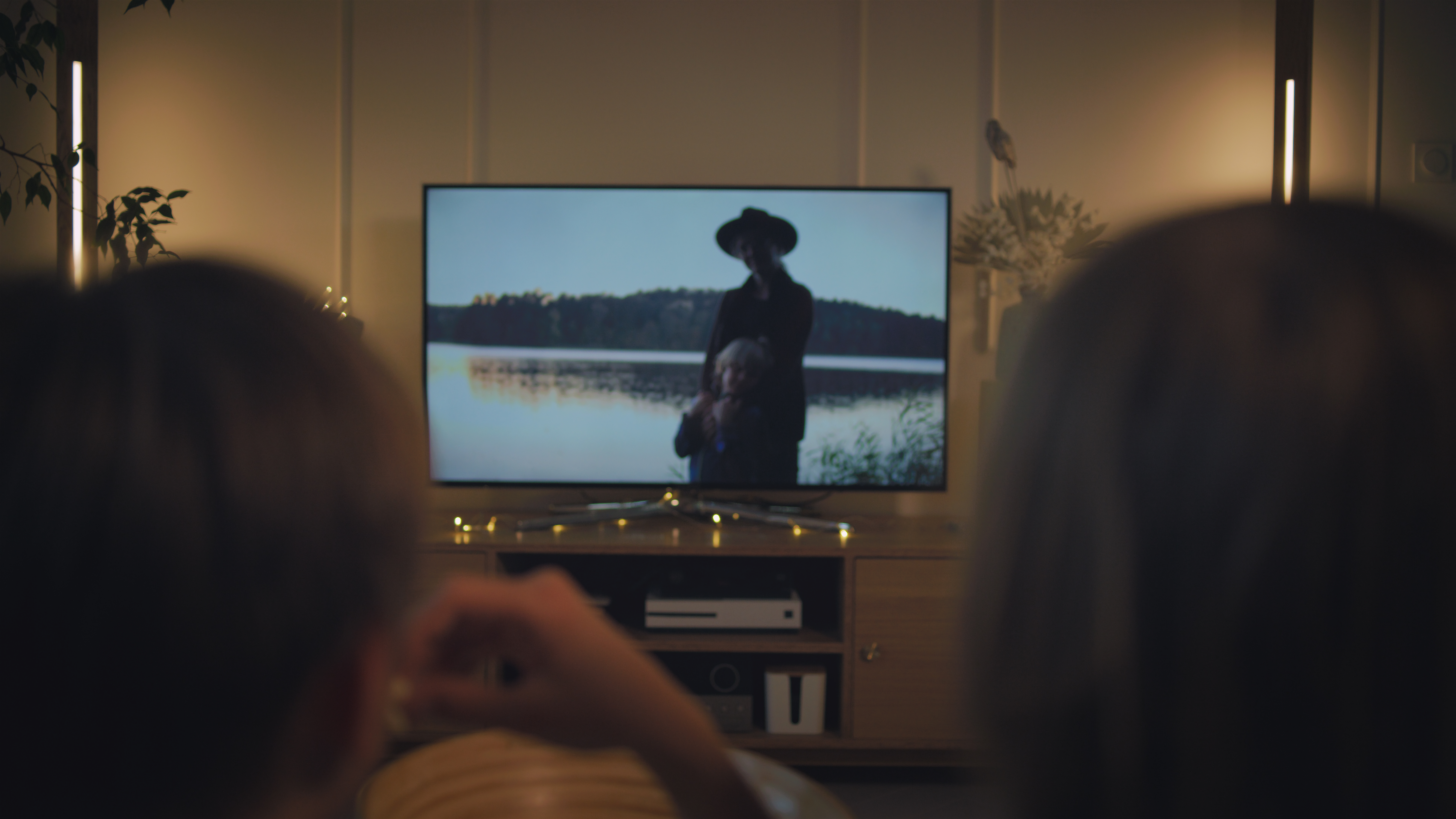 two people on a couch watching tv
