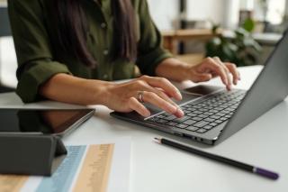 womans hands working on laptop keyboard