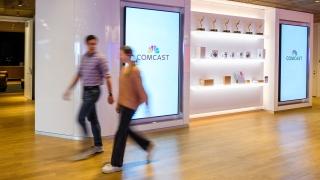 people walking by a wall with awards displayed