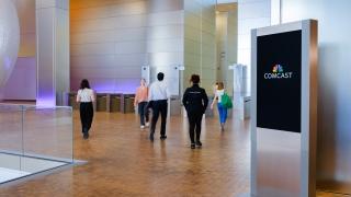 lobby with people entering through turnstiles 