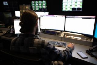 person working in front of multiple computer screens