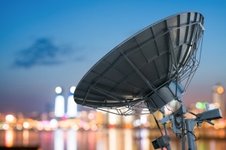 Satellite dish overlooking city lights