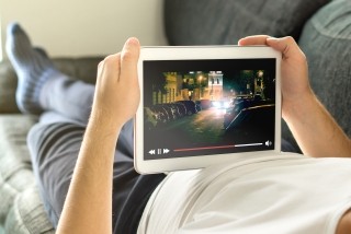Person laying down watching tablet