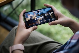hands holding a phone watching a video