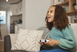 kid on a couch with a game controller in her hand