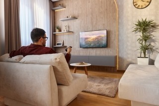 a man in a living room looking at a tv
