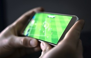 smartphone being held with soccer being watched