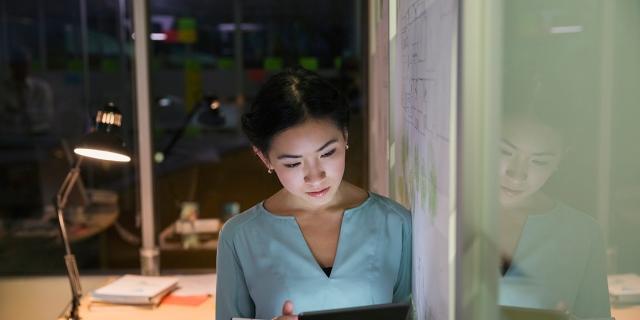 woman at whiteboard using a tablet