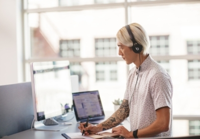 man working on laptop wearing headphones