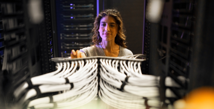 woman working on server rack cables
