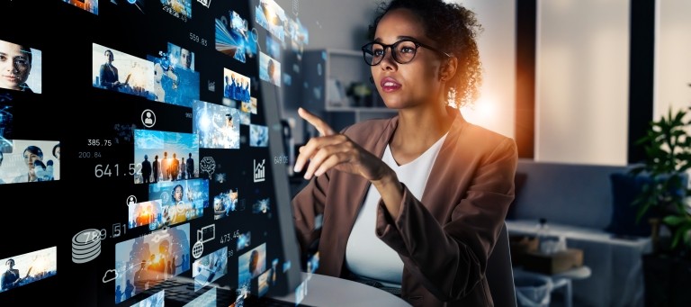 woman working on laptop with abstract screens overlayed
