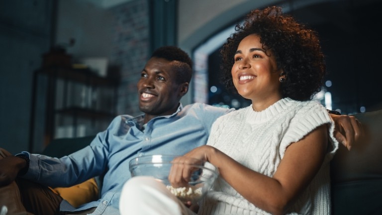 people couple watching tv popcorn