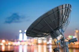 Satellite dish overlooking city lights