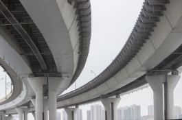 two bridges in front of a distant city