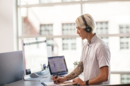 man working on laptop wearing headphones