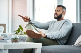man on couch holding remote