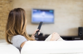 woman holding remote watching tv