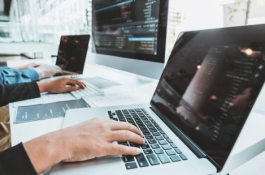 two sets of hands working on laptops