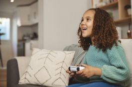 kid on a couch with a game controller in her hand