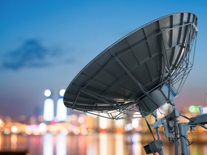 Satellite dish overlooking city lights