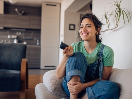 woman with remote on couch