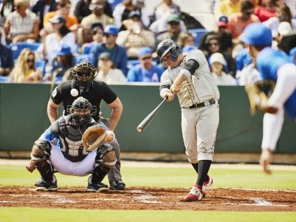 a baseball batter about to hit a ball 