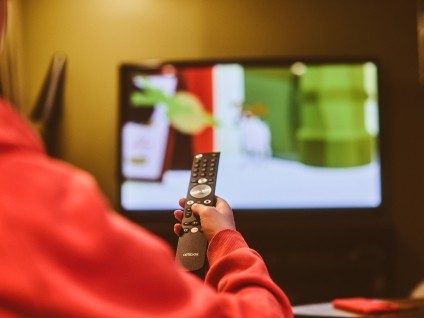 Person holding remote pointed at a TV