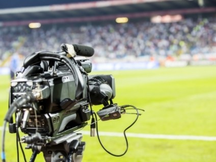 Broadcast camera positioned beside a sports field during a live event